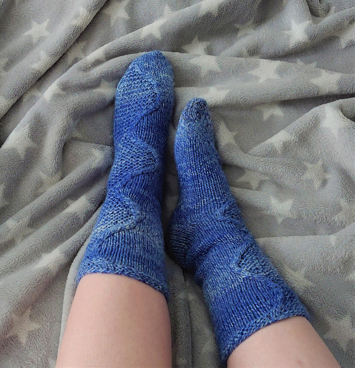 Tuonela River socks, blue cable socks on a star blanket